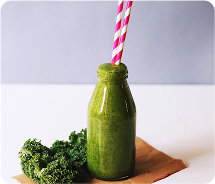 Health green juice in a bottle with two candy cane colored straws